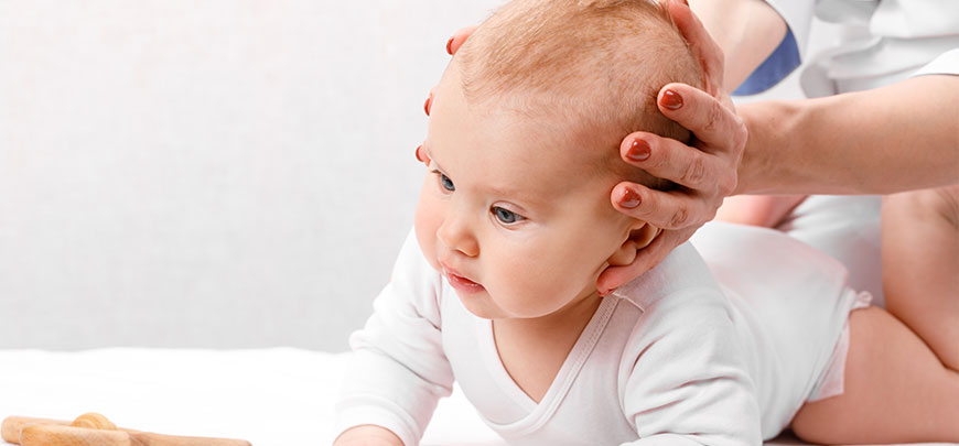 Infant receiving chiropractic adjustment for neck pain