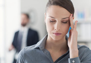 Woman with migraine in need of Chiropractic adjustment